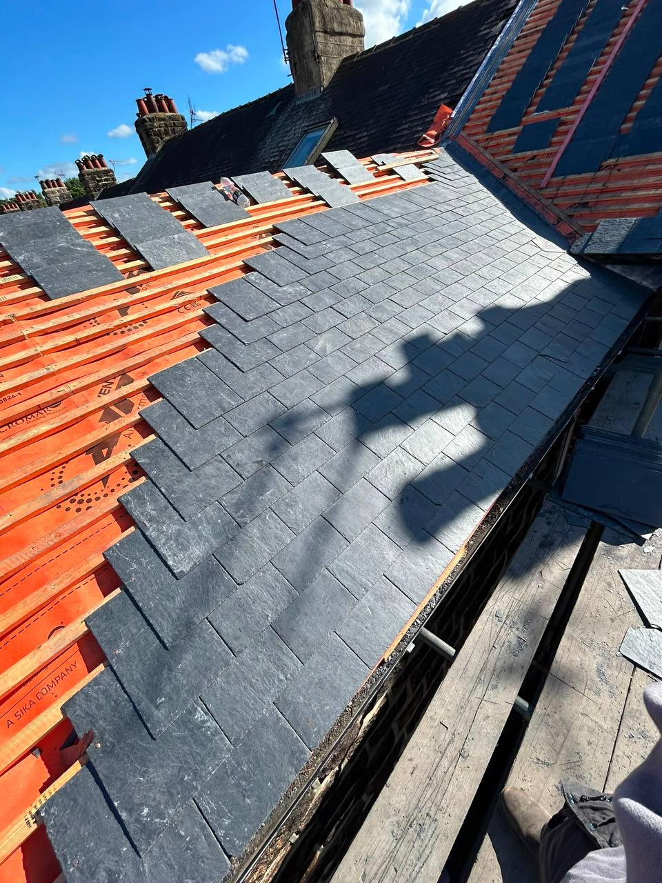 Grey slate pitched roof with chimney